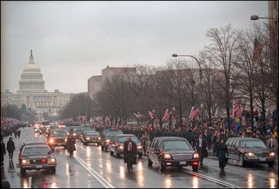 Thousands of spectators watch as the motorcade of newly inaugurated President George W. Bush drives along the parade route in Washington, D.C., Jan. 20, 2001. 