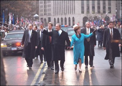 President George W. Bush and Laura Bush wave as they walk down Pennsylvania Avenue during the Inaugural Parade in Washington, D.C., Jan. 20, 2001.