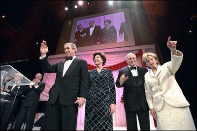 President-elect George W. Bush, Laura Bush, Vice President-elect Dick Cheney, and Lynne Cheney wave at a dinner reception held in honor of the inauguration in Washington, D.C., Jan. 18, 2001. 
