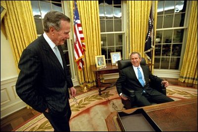 After being sworn in as the 43rd President of the United States, George W. Bush shares his first private moments in the Oval Office with his father, former President George H. W. Bush, Jan. 20, 2001.