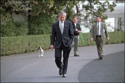 Followed closely by his dog Spot, President George W. Bush walks alone on the South Lawn March 19, 2004. In an address to the nation that evening, President Bush announced the start of Operation Iraqi Freedom.
