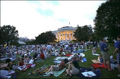 Awaiting a show of explosions of color, White House staff members and their families relax on the South Lawn Thursday, July 4. Shortly before the fireworks began, President Bush joined the party and watched the display from the Truman Balcony.