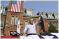 President George W. Bush waves to the estimated 3,000 people in attendance at an Independence Day celebration Monday, July 4, 2005, at West Virginia University in Morgantown. Said the President, "The history we celebrate today is a testament to the power of freedom to lift up a whole nation."