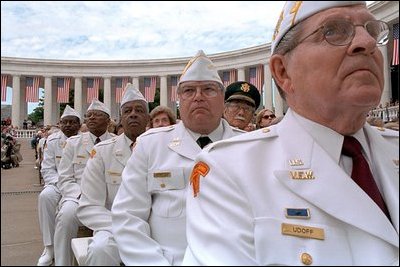 Veterans listen to President Bush speaks during Memorial Day ceremonies at Arlington National Cemetery May 28, 2001. "It is not in our nature to seek out wars and conflicts. But whenever they have come, when adversaries have left us no alternative, American men and women have stood ready to take the risks and to pay the ultimate price."