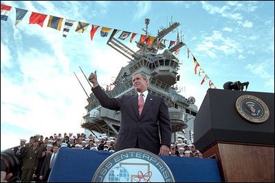 Addressing veterans, servicemen and women and families, President George W. Bush gives a thumbs-up during his speech marking the anniversary of Pearl Harbor on the U.S.S. Enterprise Dec. 7, 2001. "What happened at Pearl Harbor was the start of a long and terrible war for America. Yet, out of that surprise attack grew a steadfast resolve that made America freedom's defender. And that mission -- our great calling -- continues to this hour, as the brave men and women of our military fight the force of terror in Afghanistan and around the world," said the President.