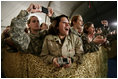U.S. and Coalition troops cheer and take photos Wednesday, March 1, 2006, during an appearance by President George W. Bush and Mrs. Laura Bush at Bagram Air Base in Afghanistan.