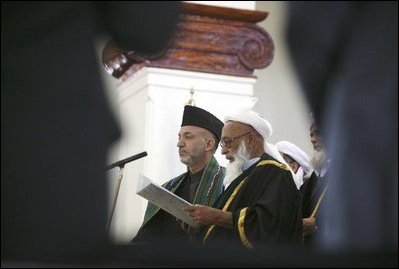 President of Afghanistan Hamid Karzai is sworn in by Afghanistan Supreme Court Chief Justice Fazil Hadi Shinwari during President Karzai.s inauguration ceremony at Salaam Khana in Kabul, Afghanistan, Dec. 7, 2004.