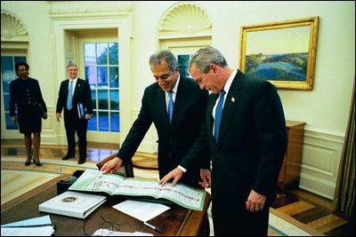 Meeting in the Oval Office, Dr. Zalmay Khalilzad, U.S. Ambassador to Afghanistan, presents President George W. Bush an Afghan ballot from the first democratic election in Afghanistan Oct. 18, 2004. Despite the threat of terrorists attacks, about 8.4 million people voted in the election.