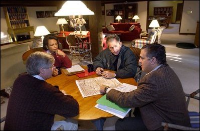 Meeting at Camp David, President George W. Bush looks over a map of Afghanistan with Chief of Staff Andy Card, left, National Security Advisor Condoleezza Rice, and CIA Director George Tenent Sept. 29, 2001. “This war will be fought wherever terrorists hide, or run, or plan. Some victories will be won outside of public view, in tragedies avoided and threats eliminated. Other victories will be clear to all,” said the President during a national radio address the same day.