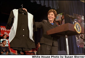 Mrs. Bush displays a sample of the school uniforms that will be made for girls in Afghanistan -- many of whom will attend school for the first time on March 23 when the new school year begins. Mrs. Bush announced a new global partnership of government agencies, private organizations, individuals and corporations to help provide school uniforms and jobs for the women and girls of Afghanistan.