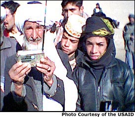 Afghan man holding a USAID/OTI-supplied radio. Photo Courtesy of the USAID