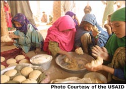  Photo of women making bread with wheat provided as part of humanitarian relief efforts. Photo courtesy of the USAID
