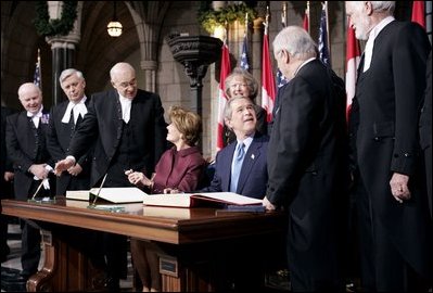 President George W. Bush and Laura Bush greet Parliament officials and sign guest books in the rotunda of Parliament Hill in Ottawa, Canada, Nov. 30, 2004. 