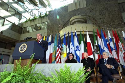"Today, I call for a new compact for global development, defined by new accountability for both rich and poor nations alike," states President George W. Bush in his address at the Inter-American Development Bank in Washington, D.C. March 14, 2002. Accompanying the President from left to right are: the lead singer of U2, Bono; Cardinal McCarrick and Worldbank President Jim Wolfensohn. White House photo by Tina Hager.
