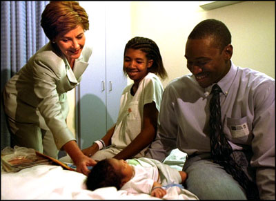 Laura Bush visits with parents Ronnie and Chakeiva Collins, a couple from Plant City, Fla. and their 2-day-old son at Tampa General Hospital on Tuesday, October 1, 2002. Mrs. Bush presented the new parents a copy of the Healthy Start, Grow Smart magazine series that provides parents with critical information about the early development, health, nutrition and safety needs of babies and toddlers. White House photo by Susan Sterner.