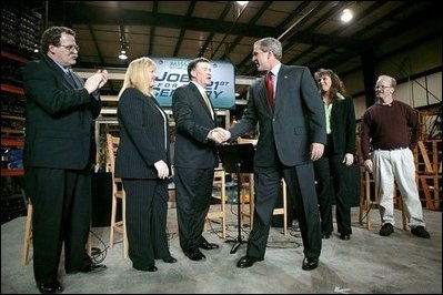 President George W. Bush greets the stage participants at the end a conversation on the economy at SRC Automotive in Springfield, Mo., Monday, Feb. 9, 2004. From left, they are Mike Sadler, President of Custom Manufacturing and Polishing; Tricia Derges, CEO of Mostly Memories; Jack Stack CEO of SRC Automotive; Teresa Noblitt, SRC Automotive accountant; and Gary Brown, SRC Automotive Warehouse Supervisor.