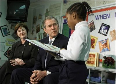 President Bush and Laura Bush listen to student Janea Bufford read at Moline Elementary School in St.Louis, Mo., Feb. 20, 2001. During his remarks, the President discussed the "Reading First" initiative, "It is a $5 billion program over five years. It will triple the amount of reading money available for local districts to access. It says that inherent in any good program is the need for districts to develop a K through 2 diagnostic tool; that is a simple tool that will enable K through 2 teachers to determine who needs help early."