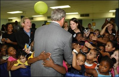 President Bush is greeted with an enthusiastic hug during a visit to Kirkpatrick Elementary School where the President highlighted the tutoring and supplemental services provided in the No Child Left Behind Act in Nashville, Tenn., Monday, Sept. 8, 2003. "So, in other words, the bill basically says, we believe in high expectations, and we believe it so strongly, we want to measure to see if those expectations are being met. It's one thing to say, I believe in high expectations; but unless you measure, you don't know whether expectations are being achieved," said the President.