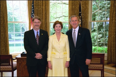 President George W. Bush and Laura Bush congratulate 2003 Maine Teacher of the Year James L. Smith in the Oval Office Wednesday, April 30, 2003. White House Photo by Eric Draper