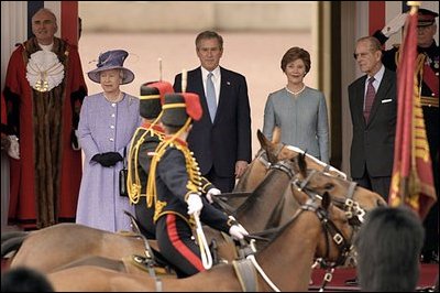 The Household Cavalry of Buckingham Palace parade by, from left, Her Majesty Queen Elizabeth, President George W. Bush, Laura Bush and Prince Philip, Duke of Edinburgh, during the ceremonial welcome at Buckingham Palace in London, Wednesday, Nov. 19, 2003. White House photo by Paul Morse