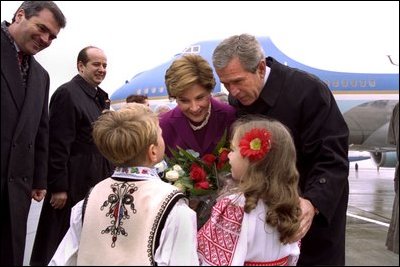 President George W. Bush and Laura Bush are greeted by children at the airport in Bucharest, Romania Saturday, Nov. 23, 2002. White House photo by Susan Sterner.