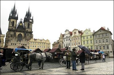 Shopkeepers gather in the morning at one of Prague's historic town squares.