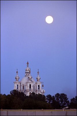 The moon rises at sunset in St. Petersburg, Russia. 