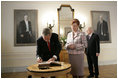 President George W. Bush signs a guest book after Latvian President Vaira Vike-Freiberga presented him the Order of the Three Stars, First-Class at Riga Castle in Riga, Latvia, Saturday, May 7, 2005. Established in 1924 to commemorate the founding of the Latvian State, the medal is awarded to recognize outstanding civil merit in the service of Latvia.