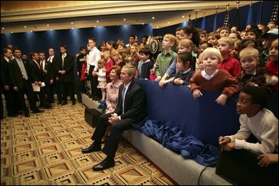 President George W. Bush and Laura Bush sit with children of embassy staff during their visit with U.S. Embassy employees Monday, Feb. 21, 2005, at the Sheraton Brussels Hotel and Towers in Brussels.