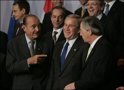 President George W. Bush talks with French President Jacques Chirac, left, and European Union President Jean-Claude Juncker as world leaders take their places for the official NATO group photo in Brussels Tuesday, Feb. 22, 2005. 