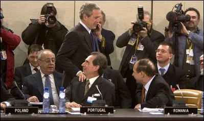 President George W. Bush walks past delegates and media as he enters a plenary session of the North Atlantic Council at NATO Headquarters in Brussels Tuesday, Feb. 22, 2005. 