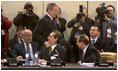 President George W. Bush walks past delegates and media as he enters a plenary session of the North Atlantic Council at NATO Headquarters in Brussels Tuesday, Feb. 22, 2005. 