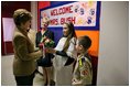 Hainerberg elementary students Montana Feix and Matt Bowlsby greet Laura Bush as she arrives to the school Tuesday, Feb. 22, 2005, in Wiesbaden, Germany. During her visit to the school Mrs. Bush heard a recital by the school chorus and talked with a group of fourth and fifth graders. 