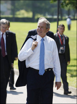 President George W. Bush walks carrying his jacket over his shoulder on his way to a meeting with European Union leaders Tuesday, June 10, 2008 at Brdo Castle in Kranj, Slovenia.