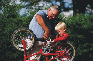 a boy and his grandfather work on a bike