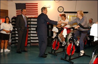Accompanied by the Governor of Florida, his brother Jeb Bush, President George W. Bush visits senior citizens participating in an aerobic "spinning class" at the Marks Street Senior Recreation Complex in Orlando, Fla., Friday, June 21, 2002.