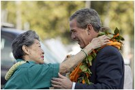 President Bush is greeted by USA Freedom Corps Greeter Hilma Chang at Hickam Air Force Base in Honolulu, Hawaii, Oct. 23, 2003.
