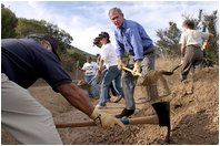Working alongside volunteers, President George W. Bush lends a hand in repairing the Old Boney Trail at the Santa Monica Mountains National Recreation Area in Thousand Oaks, Calif., Aug. 15, 2003.