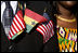 Flags of the United States and Ghana are displayed by a guest attending the South Lawn Arrival Ceremony for President John Agyekum Kufuor of Ghana Monday, Sept. 15, 2008, at the White House.