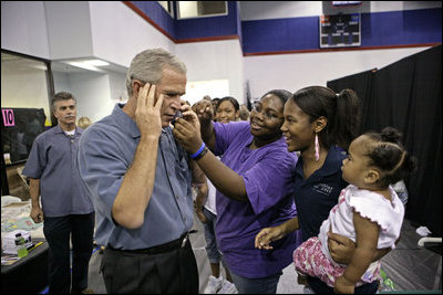 President George W. Bush takes part in a phone call at the Bethany World Prayer Center shelter, Monday, Sept. 5, 2005 in Baton Rouge, Louisiana. The facility is housing hundreds of people displaced by Hurricane Katrina. 