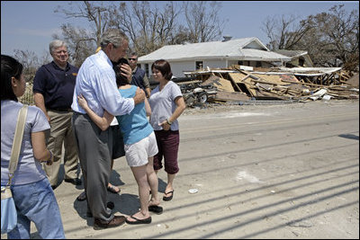 President George W. Bush comforts a family during his walking tour through neighborhoods damaged by Hurricane Katrina in Biloxi, Miss., Sept. 2, 2005.