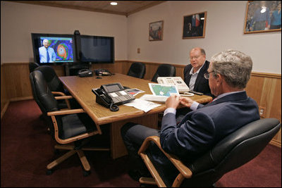 President George W. Bush is handed a map by Deputy Chief of Staff Joe Hagin during a video teleconference with federal and state emergency management organizations on Hurricane Katrina from his Crawford, Texas, ranch Sunday August 28, 2005. 