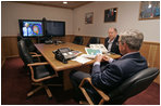 President George W. Bush is handed a map by Deputy Chief of Staff Joe Hagin during a video teleconference with federal and state emergency management organizations on Hurricane Katrina from his Crawford, Texas, ranch Sunday August 28, 2005. 