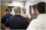President Bush discusses hurricane damage in the Coast Guard Aviation Training Center at the Mobile Regional Airport Sept. 2, 2005. 