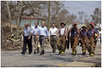 President Bush walks with Biloxi Mayor AJ Holloway, Mississippi Senator Trent Lott and firemen through the neighborhood damaged by Hurricane Katrina in Biloxi, Miss., Sept. 2, 2005. 