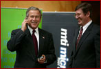 President George W. Bush tries out a cell phone powered by hydrogen fuel cell technology during a demonstration of energy technologies at The National Building Museum in Washington, D.C., Thursday, Feb. 6, 2003. Accompanied by EPA Administrator Christie Todd Whitman and Department of Energy Secretary Spencer Abraham, the President reviewed fuel cell technology in applications ranging from cars to laptop computers. White House photo by Paul Morse.