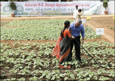 President George W. Bush greets a student in the middle of a field during his visit Friday, March 3, 2006, to the Acharya N.G. Ranga Agriculture University in Hyderabad, India. The President ended his visit to India Friday, flying to Pakistan for a day before heading back to Washington.