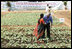 President George W. Bush greets a student in the middle of a field during his visit Friday, March 3, 2006, to the Acharya N.G. Ranga Agriculture University in Hyderabad, India. The President ended his visit to India Friday, flying to Pakistan for a day before heading back to Washington.