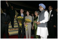 President George W. Bush and Mrs. Bush stand with flowers presented upon their arrival Wednesday, March 1, 2006, at New Delhi's Indira Gandhi International Airport where they were greeted by India's Prime Minister Manmohan Singh, right, and his wife, Gursharan Kaur.
