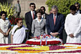 President George W. Bush and Laura Bush are joined by Rajnish Kumar, right, Secretary of the Rajghat Samadhi Committee, and Dr. Nirmila Deshpande, co-Chair of the Rajghat Gandhi Samadhi committee, for a moment of silence at the Mahatma Gandhi Memorial in Rajghat, India.